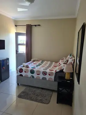 a bedroom with a bed and a table with a lamp at Pemba's residence in Cape Town