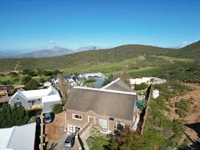 an aerial view of a house with mountains in the background at 19th Hole Golf Villa Guesthouse in Worcester