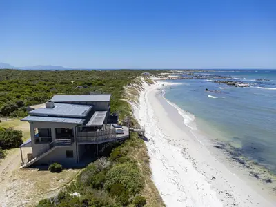 an aerial view of a house on the beach at Hangklip Villa in Pringle Bay