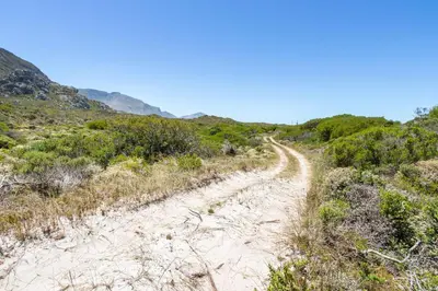 a dirt road in the middle of a field at Hangklip Villa in Pringle Bay