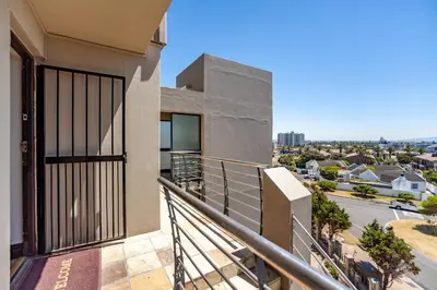 a balcony with a view of a city at Luxury 3 bedroom Duplex Penthouse with communal swimming pool in Bloubergstrand