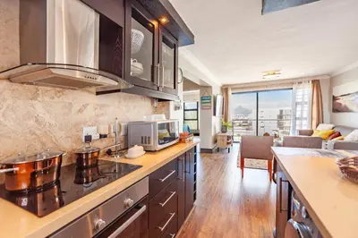 a kitchen with a counter top with a microwave at Luxury 3 bedroom Duplex Penthouse with communal swimming pool in Bloubergstrand
