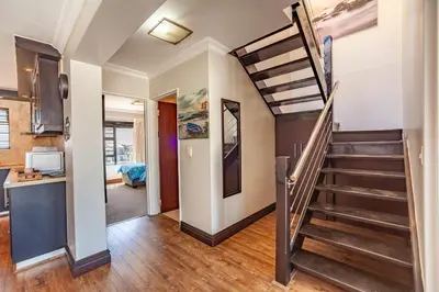 a hallway with a staircase in a house at Luxury 3 bedroom Duplex Penthouse with communal swimming pool in Bloubergstrand