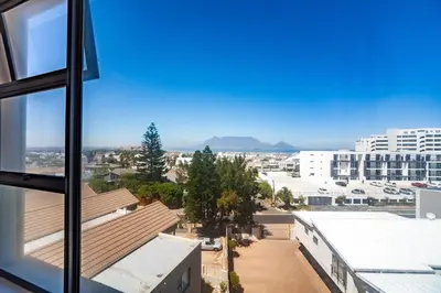 a view from a window of a city at Luxury 3 bedroom Duplex Penthouse with communal swimming pool in Bloubergstrand