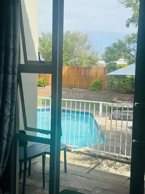 a view of a swimming pool from a window at Tranquil Pool View in Cape Town