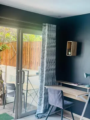 a living room with a table and a sliding glass door at Tranquil Pool View in Cape Town