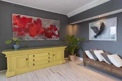 a living room with a yellow dresser and a couch at Banhoek Lodge in Stellenbosch