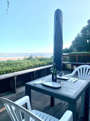 a picnic table with a bottle of wine and two chairs at Fantastic spot In Hermanus with great lagoon views in Hermanus