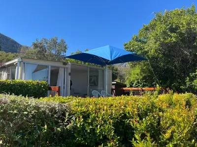 a blue umbrella in front of a house at Fantastic spot In Hermanus with great lagoon views in Hermanus