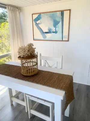 a white table with a basket of flowers on it at Fantastic spot In Hermanus with great lagoon views in Hermanus