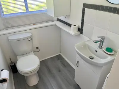 a white bathroom with a toilet and a sink at Fantastic spot In Hermanus with great lagoon views in Hermanus