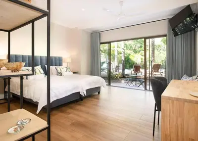 a bedroom with a bed and a desk with a table at The Oasis of Stellenbosch in Stellenbosch