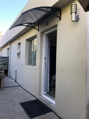 a house with an umbrella over the door at Self Catering Guest House in Cape Town