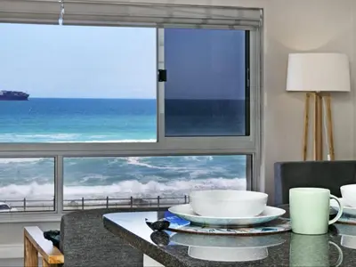 a table with a view of the ocean through a window at Zeezicht 204 Bloubergstrand in Bloubergstrand
