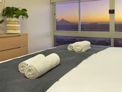 two towels on a bed in front of a window at Zeezicht 204 Bloubergstrand in Bloubergstrand