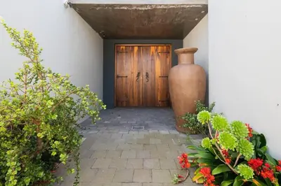 a large vase sitting in front of a door at Family home in Tableview, close to Dolphin Beach. in Cape Town