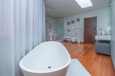 a white bathroom with a tub and a sink at Family home in Tableview, close to Dolphin Beach. in Cape Town