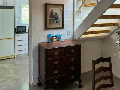 a wooden dresser in a room with a staircase at Bordeaux 45 in Cape Town
