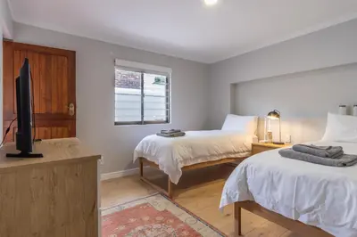 a bedroom with two beds and a flat screen tv at 3 on Vermont in Hermanus
