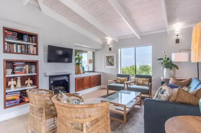 a living room with wicker chairs and a fireplace at 3 on Vermont in Hermanus