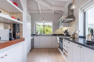 a kitchen with white cabinets and a large window at 3 on Vermont in Hermanus