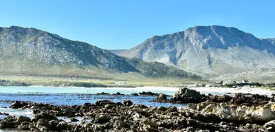 a beach with rocks and mountains in the background at Happy Place Pringle Bay for 2 in Pringle Bay