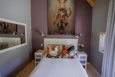 a bedroom with a bed with a painting on the wall at Berghuis - Mountain Hideaway in Wolseley