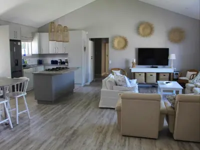 a large living room with a kitchen and a living room at Nest Egg Holiday Home Voëlklip in Hermanus