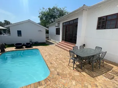 a patio with a table and chairs next to a house at Franschhoek - A Sensory Escape in Franschhoek