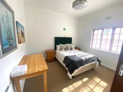 a bedroom with a bed and a wooden table at Franschhoek- African dream in Franschhoek