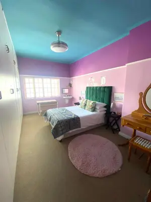 a bedroom with a bed and a purple wall at Franschhoek- African dream in Franschhoek
