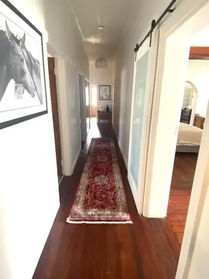 a hallway with a rug on the floor and a horse picture at Franschhoek- African dream in Franschhoek
