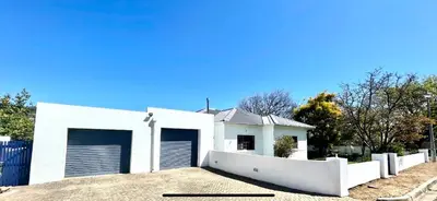 a white house with two garage doors at Franschhoek- African dream in Franschhoek