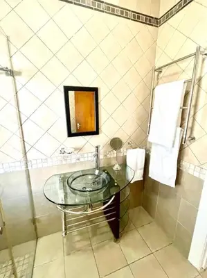 a bathroom with a glass sink and a shower at Franschhoek- African dream in Franschhoek