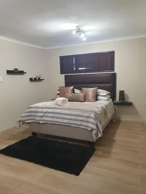 a bedroom with a large bed with brown pillows at Sunset Getaways in Cape Town