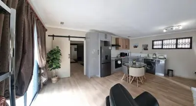 a kitchen and living room with a table and chairs at Sunset Getaways in Cape Town
