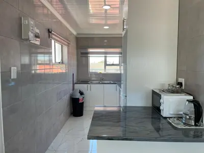a small kitchen with a sink and a counter top at The MK House in Cape Town