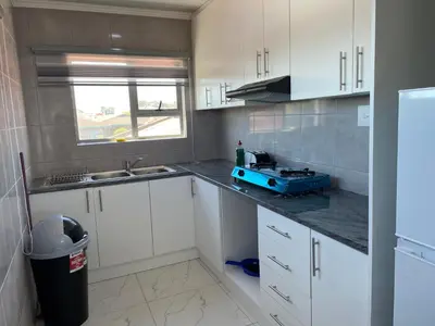 a kitchen with white cabinets and a blue appliance on the counter at The MK House in Cape Town