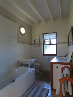 a bathroom with a tub and a toilet and a sink at Belle View Guest Suite in Hermanus