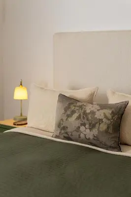 a bed with a pillow and a lamp on a table at Boho Chic Studio Stellenbosch in Stellenbosch