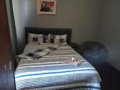 a bed with a pink object on top of it at ATHOME BELLVILLE Chrismar in Cape Town