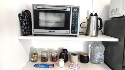 a microwave on a shelf in a kitchen at Blissful Country Garden King Bed Cottage in Grabouw