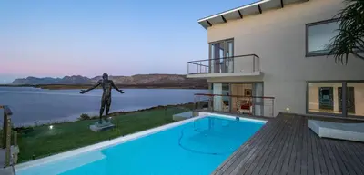 a house with a swimming pool and a statue at Benguela Cove - Lavender Dreams in Hermanus