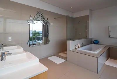 a white bathroom with two sinks and a mirror at Benguela Cove - Lavender Dreams in Hermanus