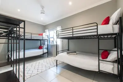 a room with three bunk beds in it at The Fuchsia Collection in Somerset West