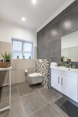 a bathroom with a sink and a toilet and a tub at The Fuchsia Collection in Somerset West