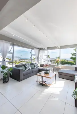 a living room with couches and a table at The Fuchsia Collection in Somerset West