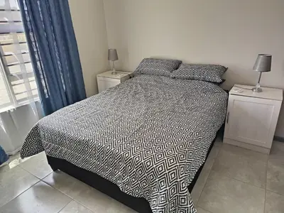 a bed with a black and white comforter in a bedroom at Nautica3 in Cape Town