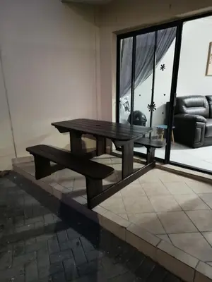 a wooden table and bench in a room with a couch at Nautica3 in Cape Town