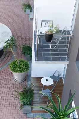 two views of a patio with plants and a table at WINK Aparthotel Quiver Tree in Stellenbosch